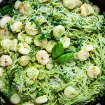 Shrimp with Shirataki noodles tossed in a green pesto sauce and presented in a large skillet.