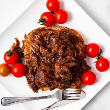 Leftover pot roast on a sandwich served with tomatoes.