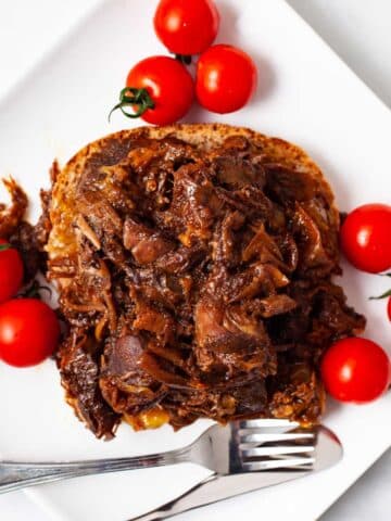 Leftover pot roast on a sandwich served with tomatoes.