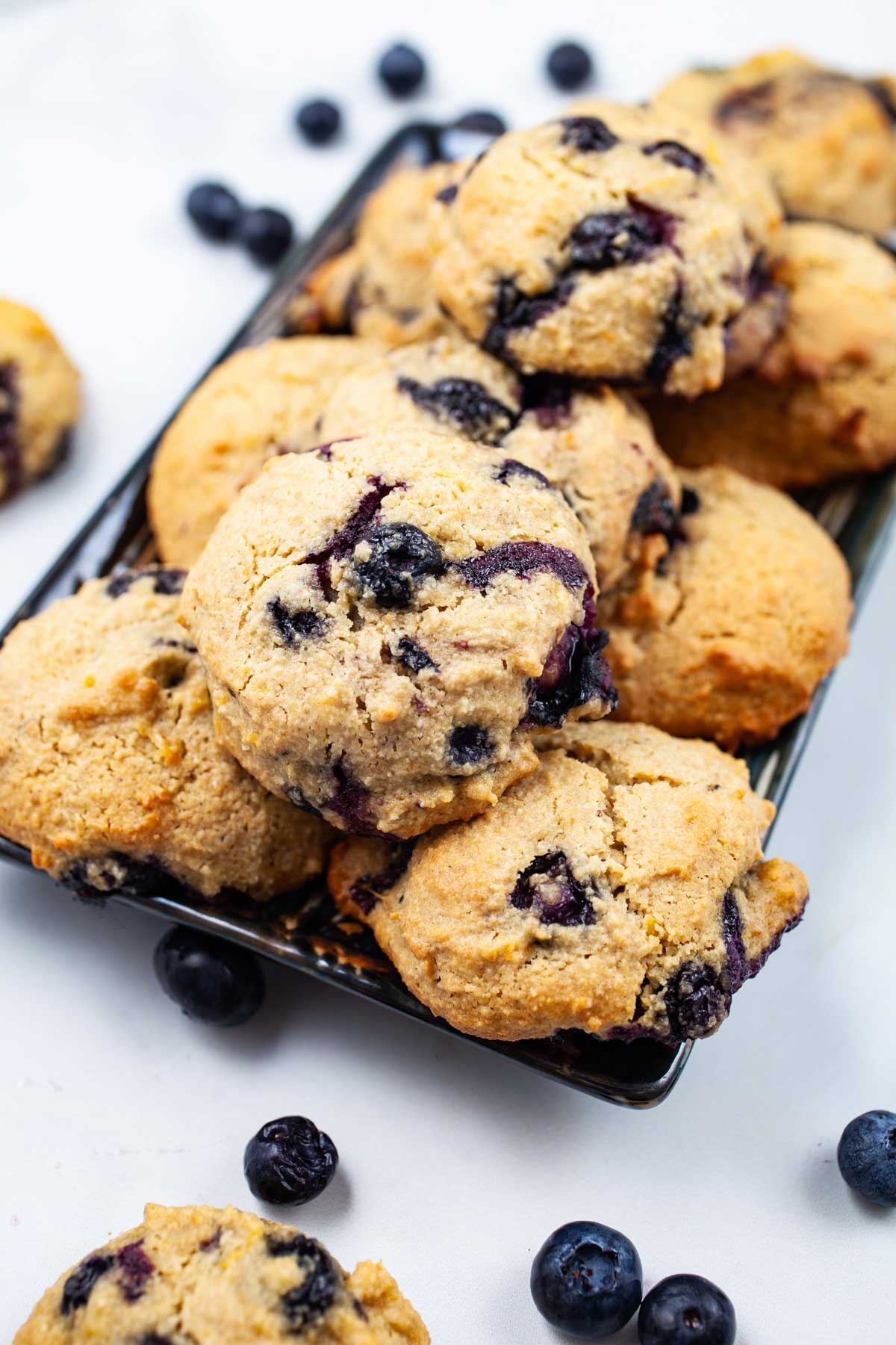 Olive oil cookies with lemon and blueberries beautifully displayed on a table.