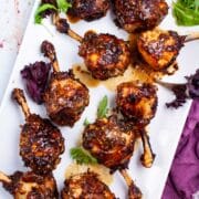 Oven baked lollipop drumsticks on a serving plate.