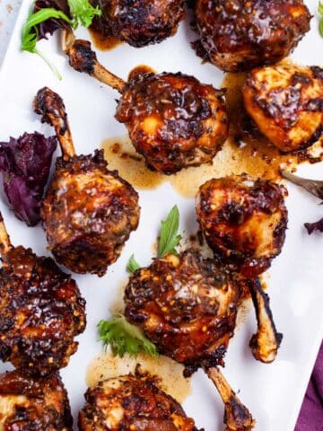 Oven baked lollipop drumsticks on a serving plate.