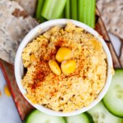 Keto hummus with lupini beans surrounded with fresh veggies and crackers.