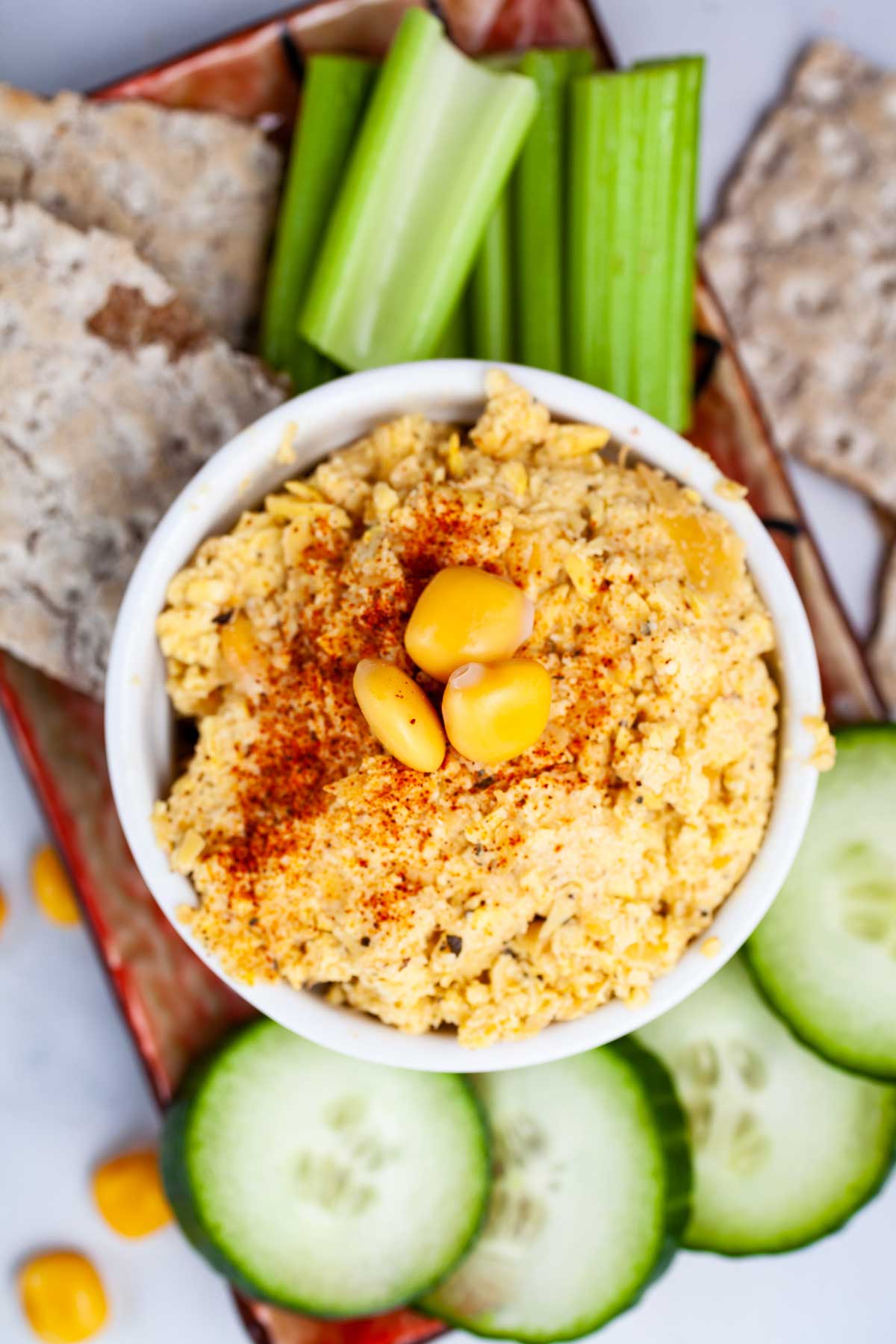 Keto hummus with lupini beans surrounded with fresh veggies and crackers.