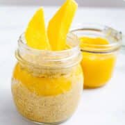 Mango coconut chia pudding served in a glass jar with mango sauce on the side.