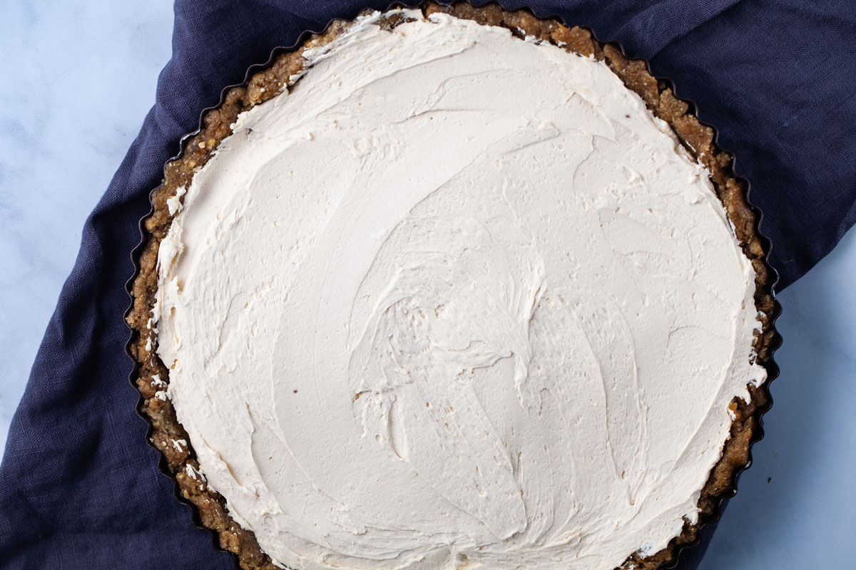 A large round tart with a no bake crust and equally filled with mascarpone cheese.