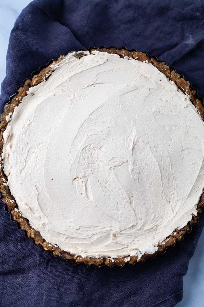A large round tart with a no bake crust and equally filled with mascarpone cheese.