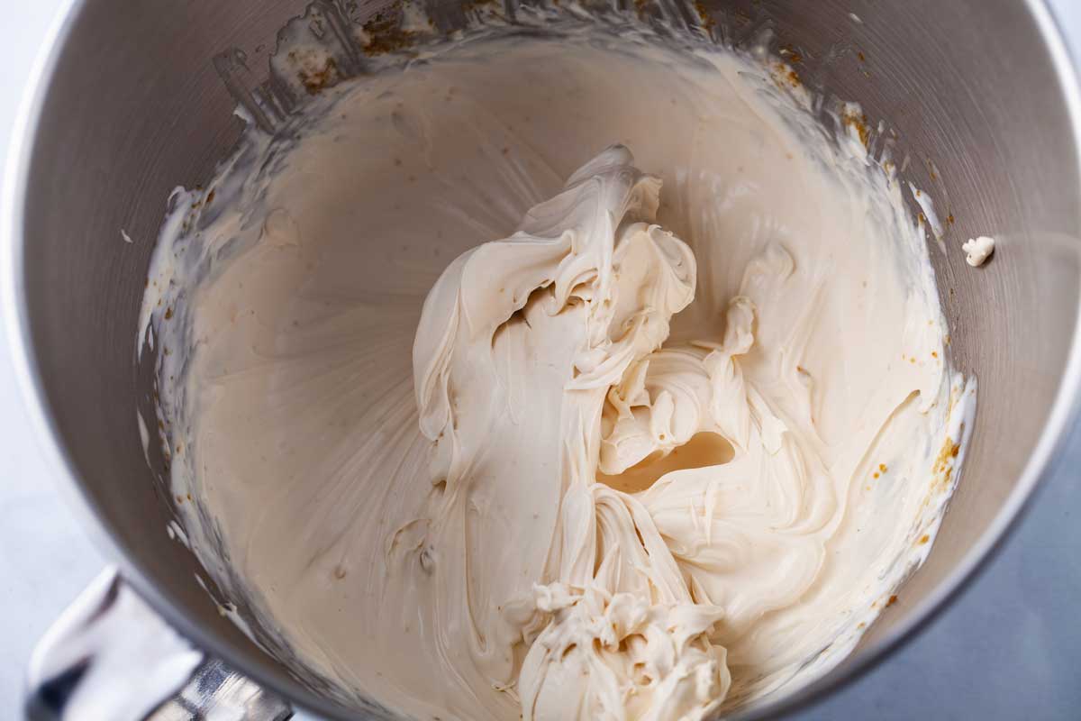 A large whisking bowl containing whipped mascarpone cheese.