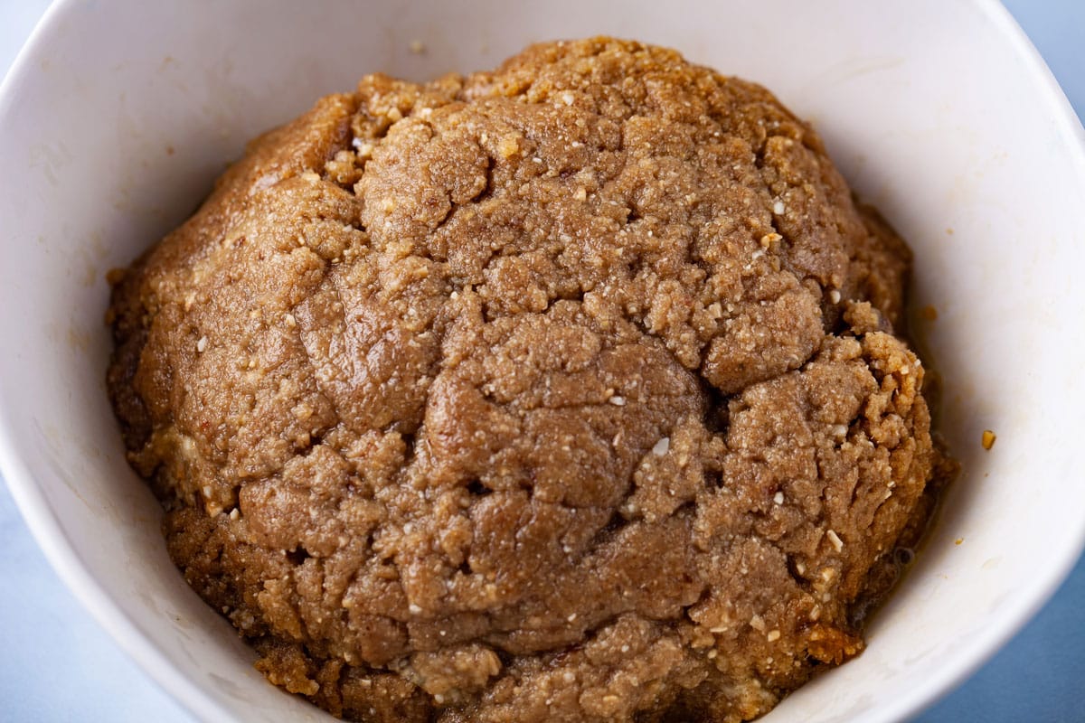 A rough ball of no-bake tart crust in a bowl.