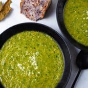 Bowls of no cream asparagus soup served with rustic bread on the side.