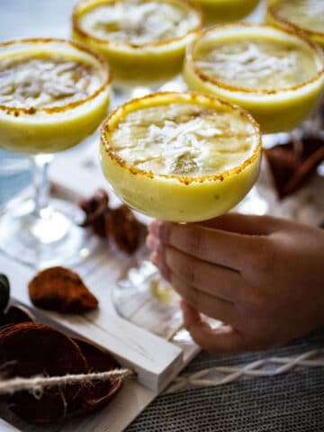 A child's hand taking a pina colada mocktail off a tray.