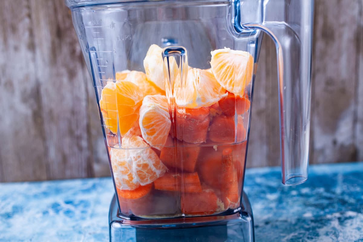 Chopped carrots, oranges and coconut water in a blender.