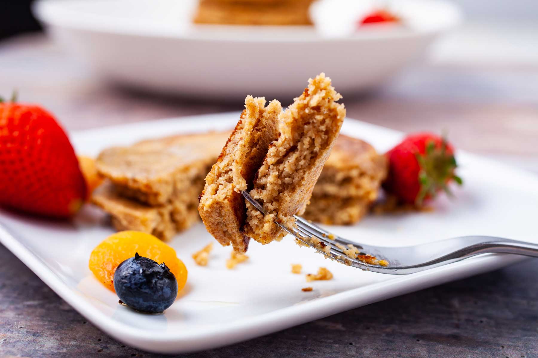A fork-full of oat flour pancake resting on a plate.