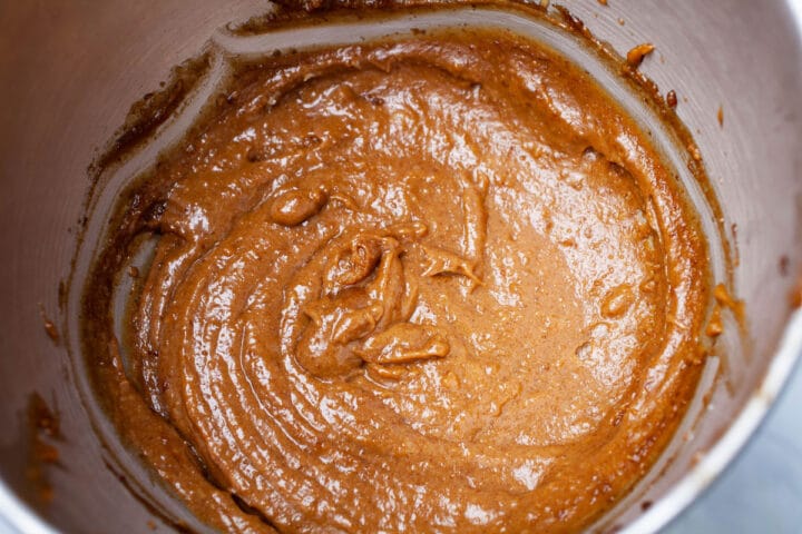 Golden brown cookie batter in a stainless steel bowl.