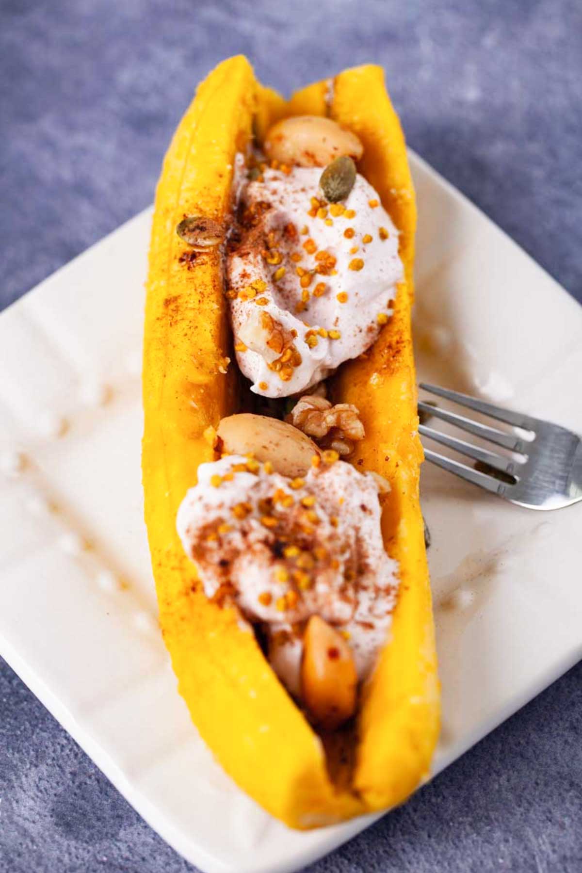 Microwaved softened sweet plantain topped with yogurt, nuts, and granola.