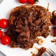 Leftover pot roast on a sandwich served with tomatoes.