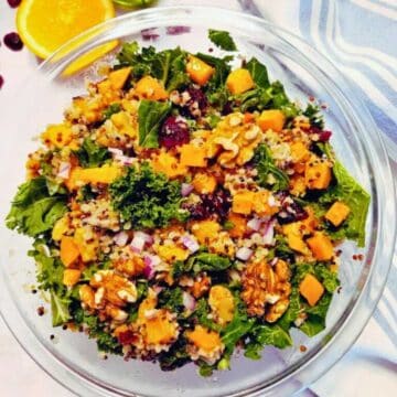 Quinoa and sweet potato salad with kale, onion and walnuts served in a salad bowl.