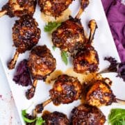 Oven baked lollipop drumsticks on a serving plate.