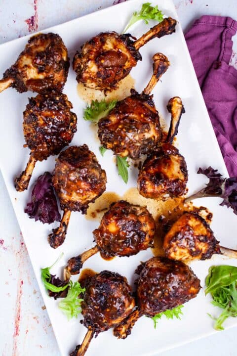Oven baked lollipop drumsticks on a serving plate.