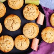 Rhubarb muffins displayed on a plate and some on the table.