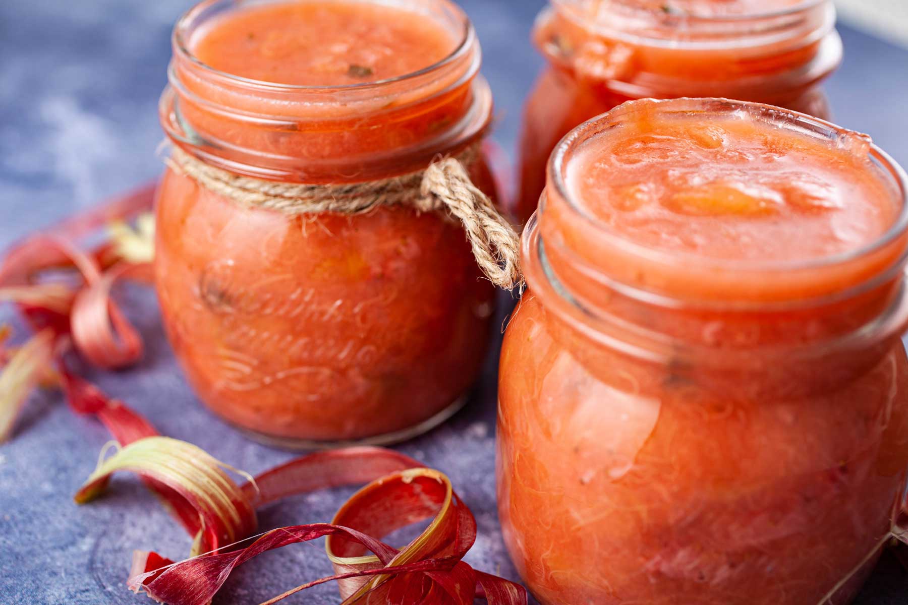 Small mason jars filled with rhubarb strawberry sauce.