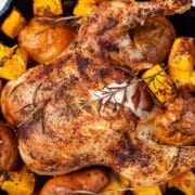 Whole roasted chicken leg, squash and pears in a cast-iron skillet.