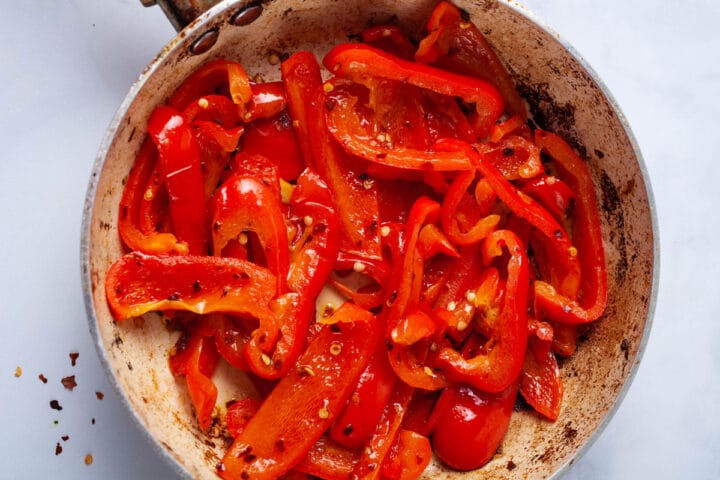 A small pan filled with sauteed julienned red bell peppers.