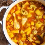 Chunky swede soup with chicken legs in a large pot.