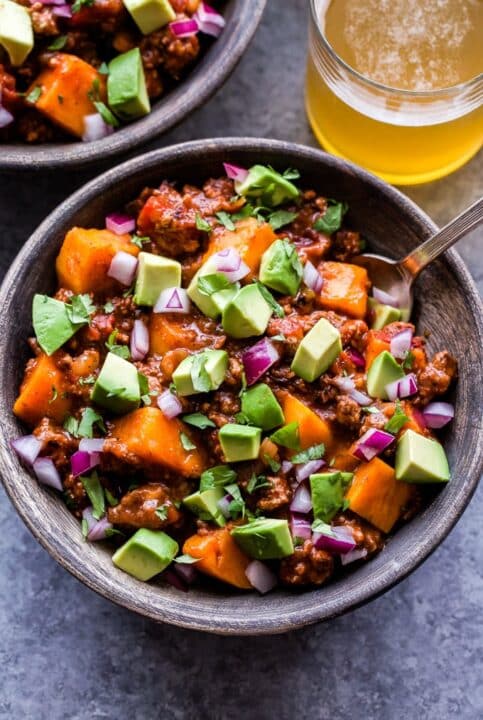 an overhead shot of bison sweet potato chili garnished with fresh avocado.