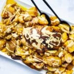 A beautiful dish with a whole chicken and potatoes topped with a healthy gravy.