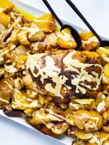 A beautiful dish with a whole chicken and potatoes topped with a healthy gravy.
