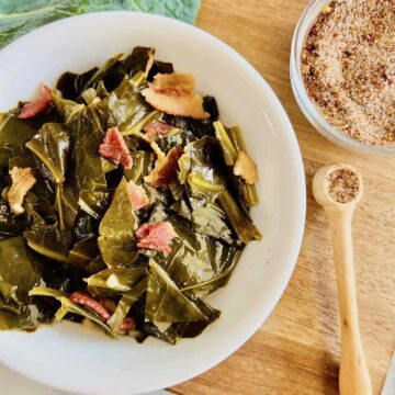 Cooked collard greens topped with bacon bits on a plate.