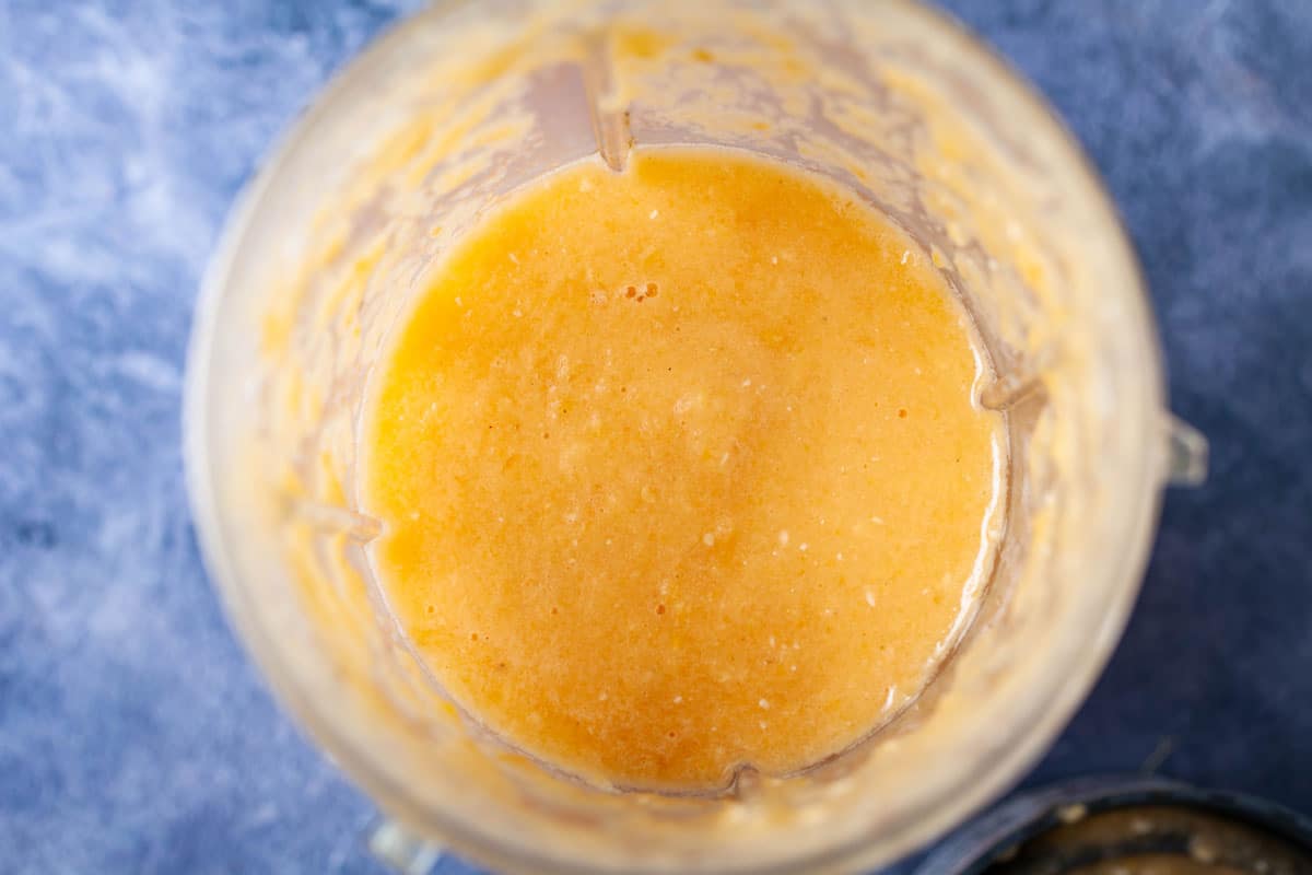 A close up of a blender filled with a smoothie drink.