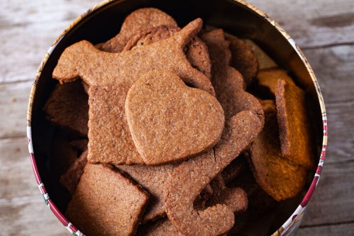 Different shaped brown cookies in a large Holiday cookie box.