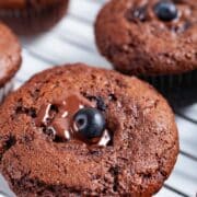 Chocolate berry jam muffins on a cooling rack.