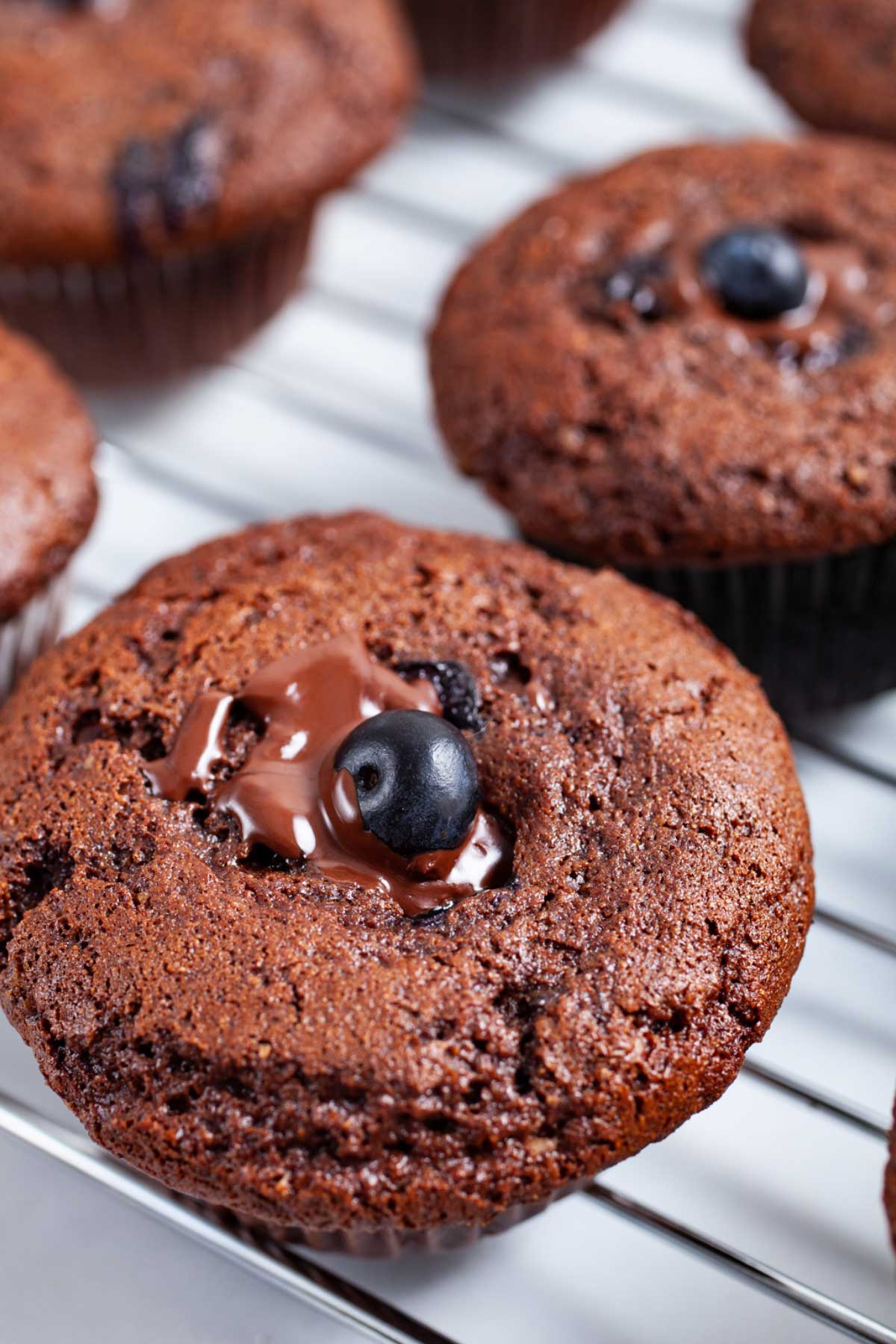 Chocolate berry jam muffins on a cooling rack.
