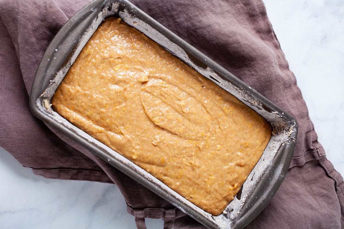 Cake batter in a prepared loaf tin pan.