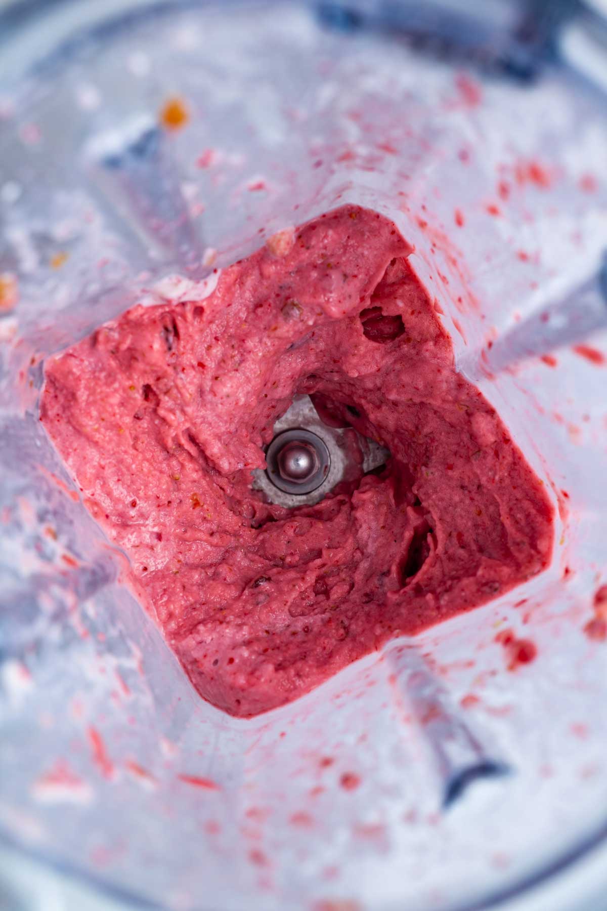 Blended frozen strawberry mixture in a blender.