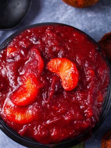 A black bowl containing mandarin orange cranberry sauce.