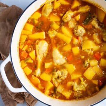 Chunky swede soup with chicken legs in a large pot.
