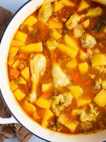 Chunky swede soup with chicken legs in a large pot.