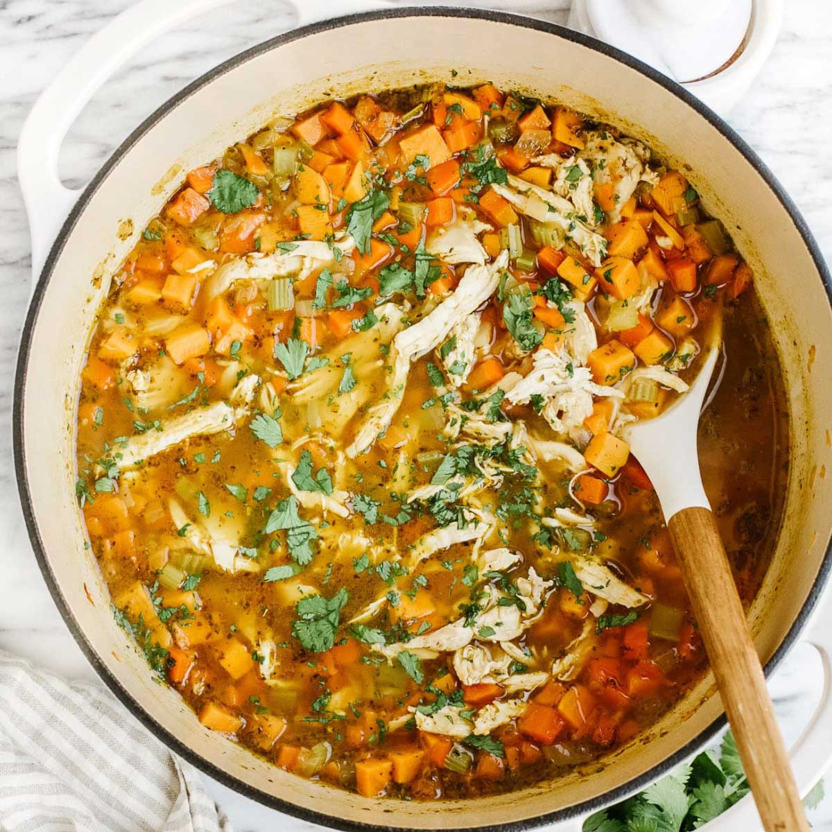 Sweet potato and shredded chicken soup in a Dutch oven pan.