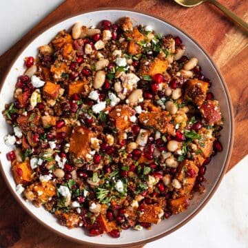 Cooked sweet potatoes, cannellini beans, pomegranate arils, feta, and herbs tossed into a salad bowl.