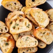 Oven-roasted garlic crostini toasts topped with garlic and fresh herbs.