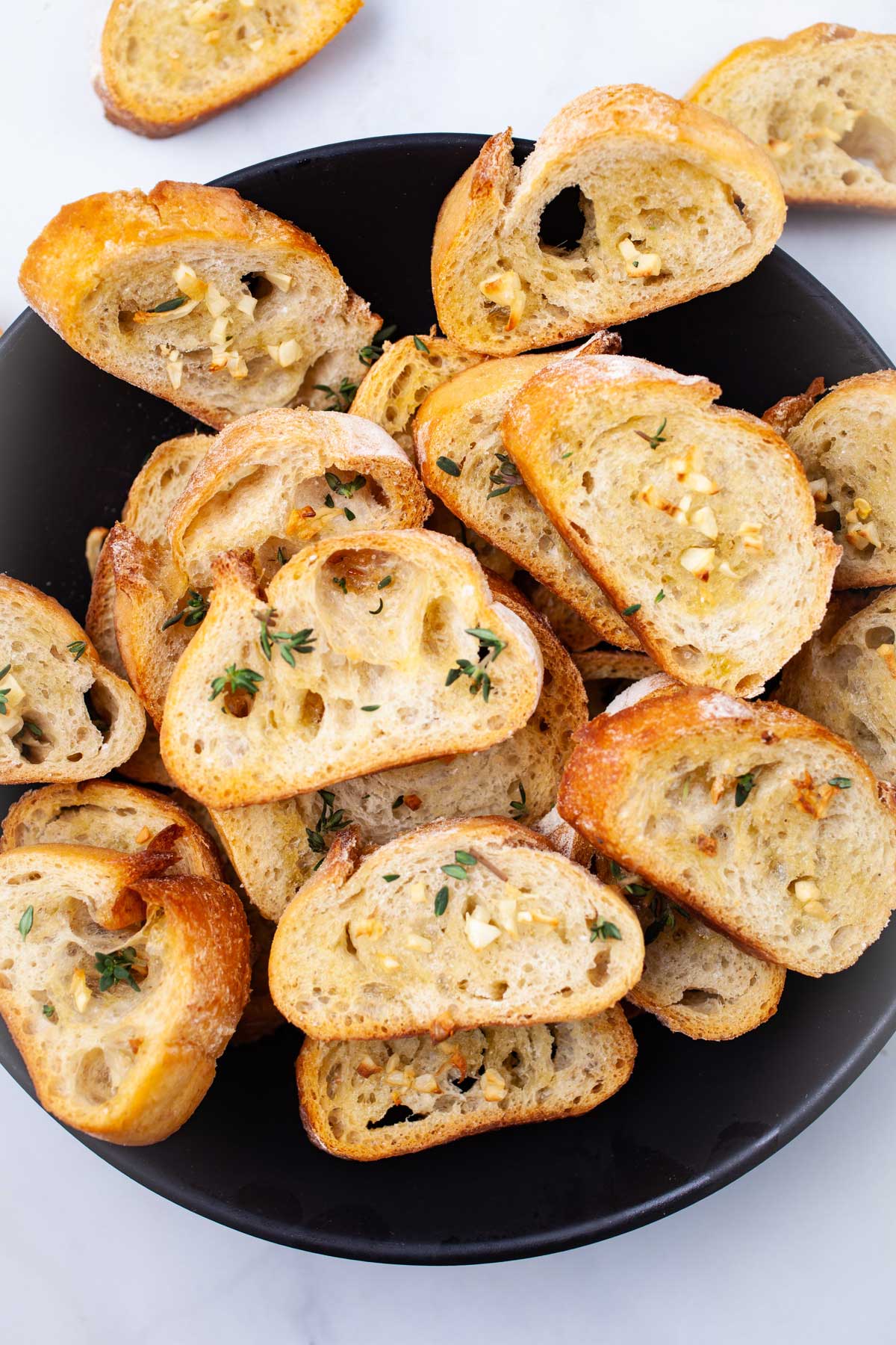 Oven-roasted garlic crostini toasts topped with garlic and fresh herbs.