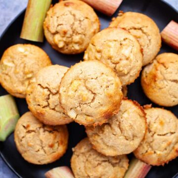 Rhubarb muffins stacked on top of each other on a plate.