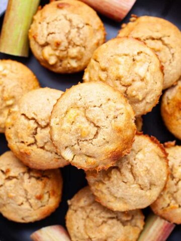 Rhubarb muffins stacked on top of each other on a plate.