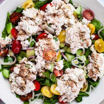 A large serving plate with a tuna cucumber salad with ricotta cheese.