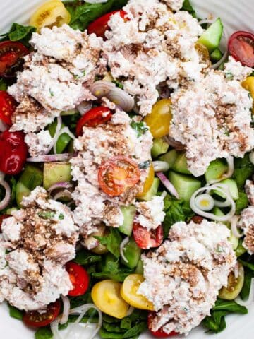 A large serving plate with a tuna cucumber salad with ricotta cheese.