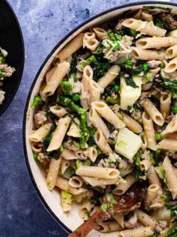 A large Dutch oven pan filled with sausage and broccoli rabe pasta.